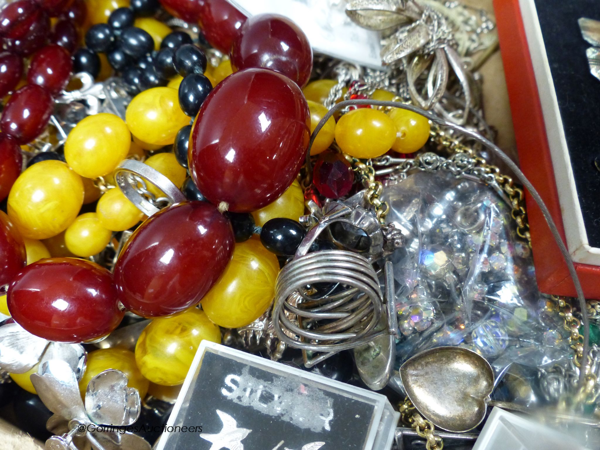 Mixed jewellery and silver etc. including a simulated cherry amber necklace, gross 81 grams, silver and 925 bracelets, rings charms, chains and a silver napkin ring.